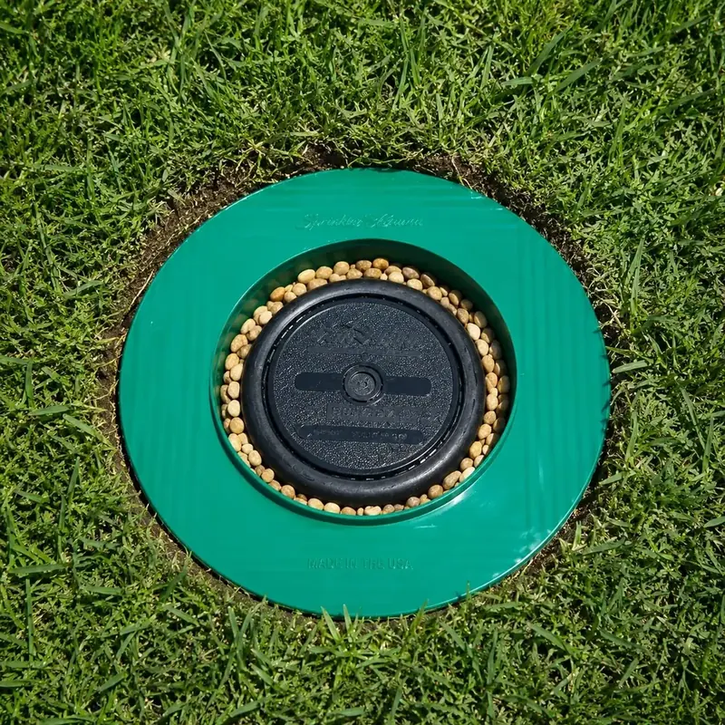 Sprinkler-Guard 5-Inch installed flush in the ground with gravel around the sprinkler head